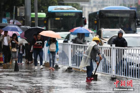 图为贵阳市环卫工人清理路面积水。 黄芷昕 摄