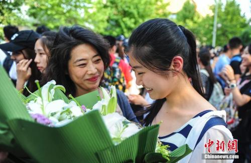 资料图：山东济南众多考生手捧鲜花在家长的簇拥下欢快告别高考。记者 张勇 摄