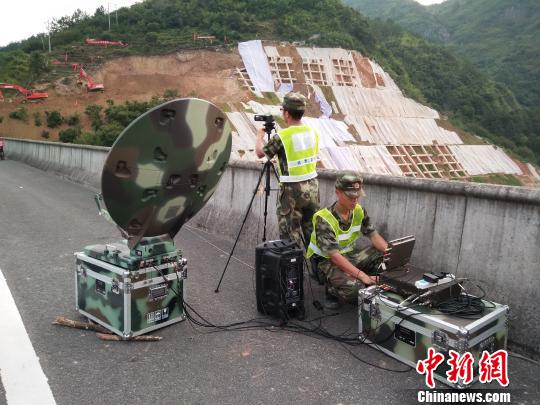 图为武警交通部队官兵利用卫星便携站实时图传影像资料。　徐明 摄