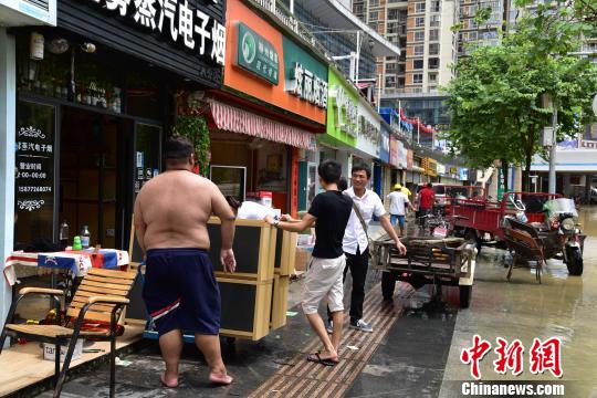 沿江店铺店主将物品搬离。　王以照 摄