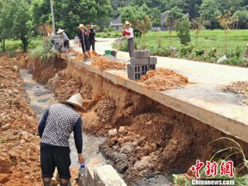 坝塘镇保安村村民自发修复被洪水冲毁的路基。　王昊昊　摄